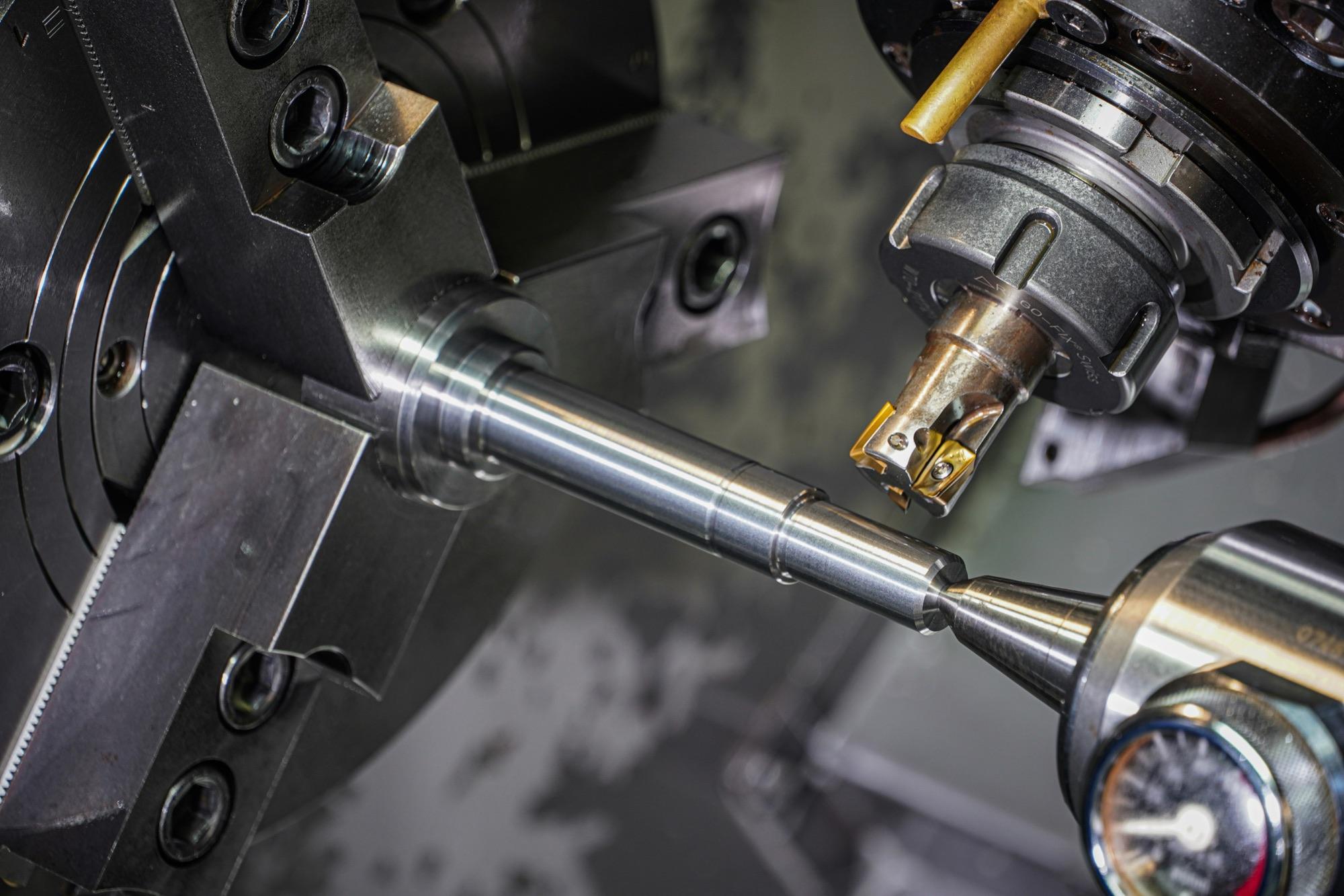 Tornio CNC durante la lavorazione di una barra metallica